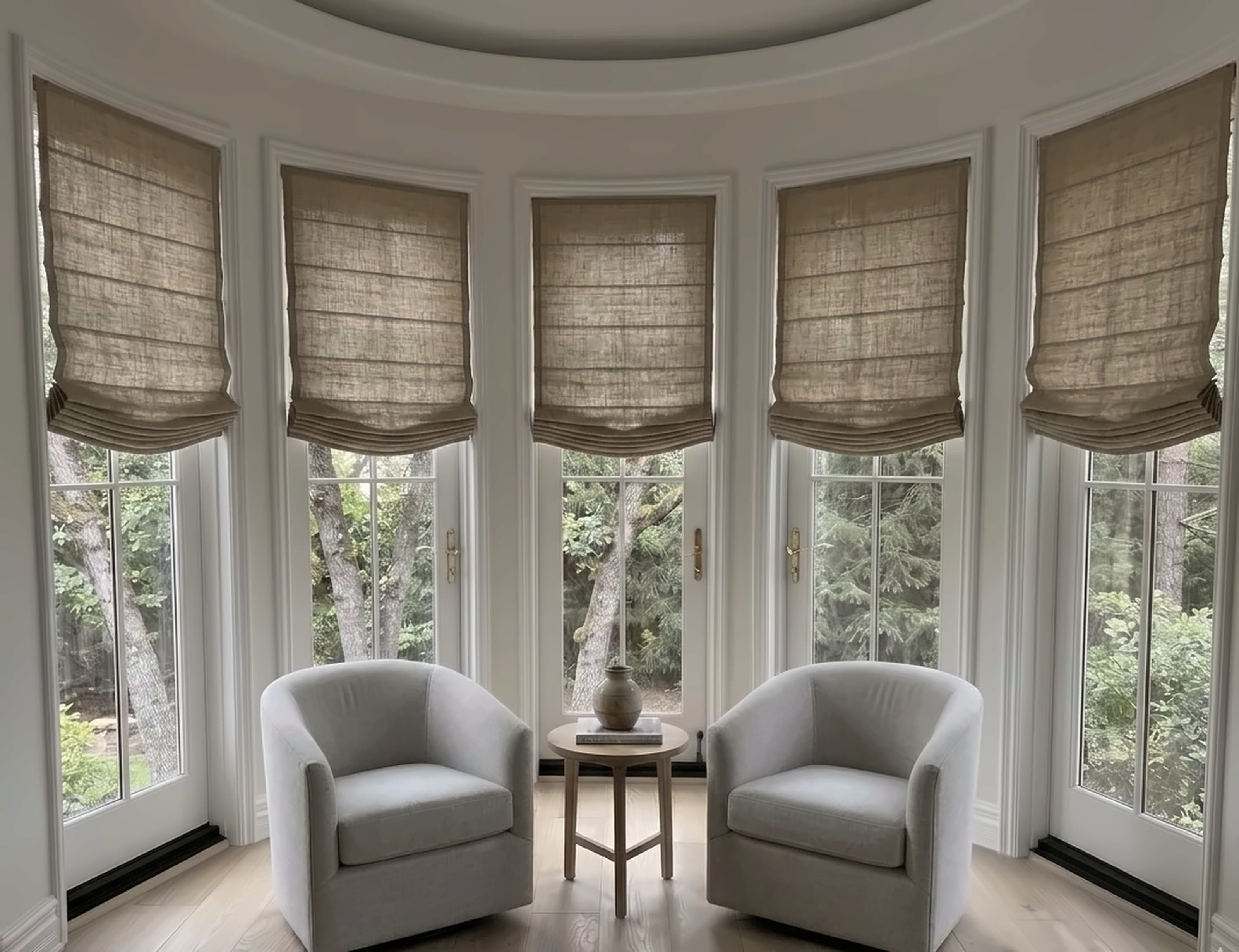 Custom linen Roman shades dressing a curved bay window in a Westside living room